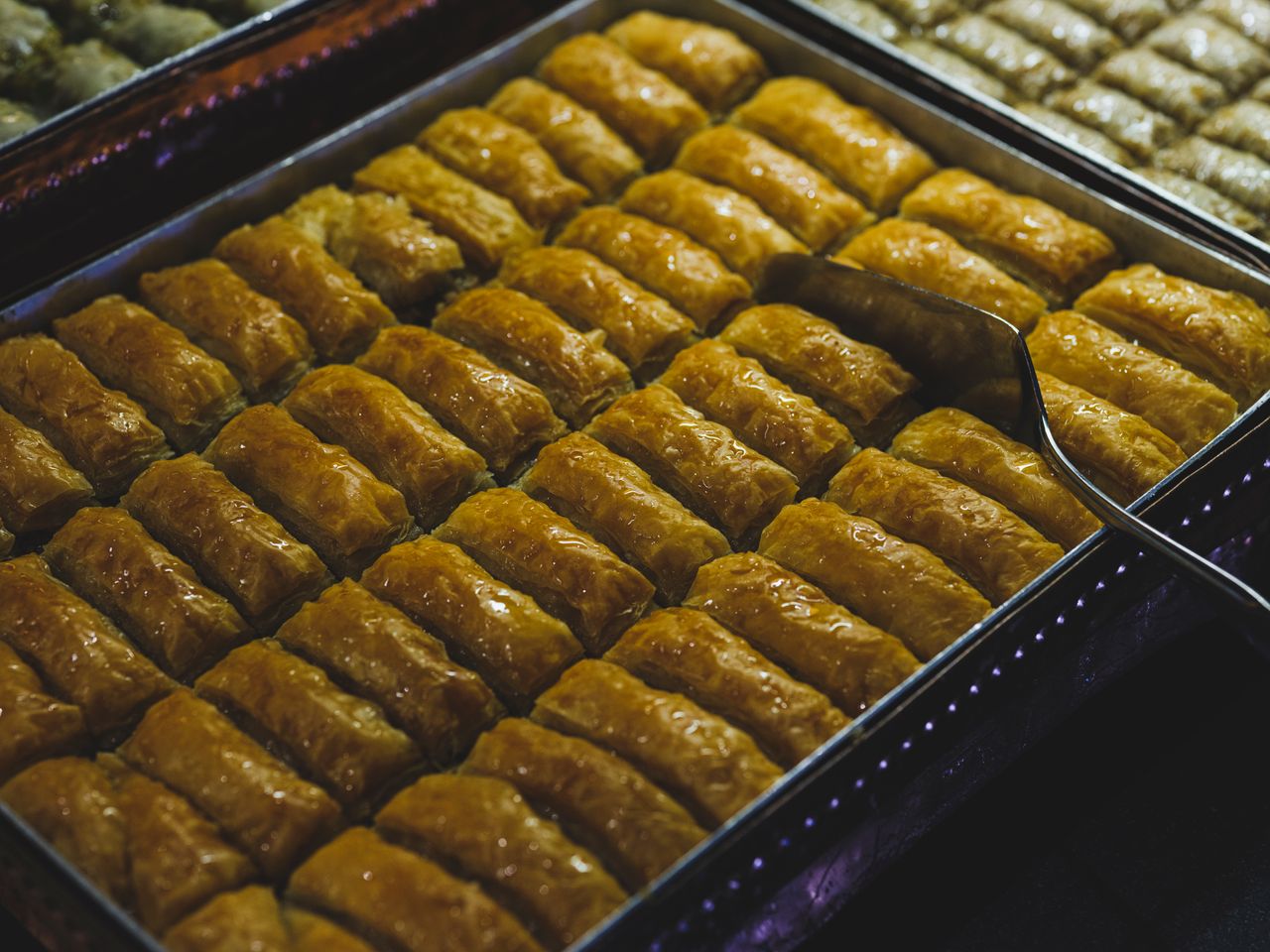 Close-up view of traditional Turkish baklava in a tray, ready to serve.
