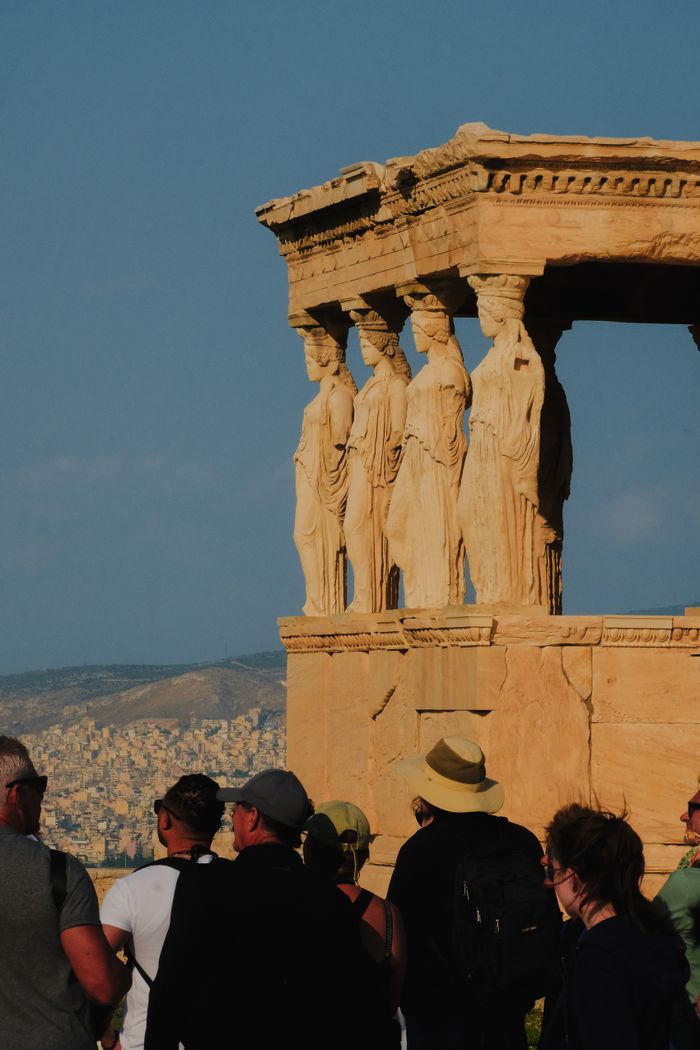 Tourists admire the Erechtheion Caryatids at the Acropolis in Athens, Greece.